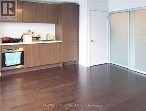 Toronto (Waterfront Communities) condo for rent - A kitchen with wooden cabinets and a white countertop.