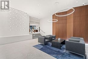 Grimsby (Grimsby Beach) condo for rent - A modern living room with a grey sofa and a wooden wall.