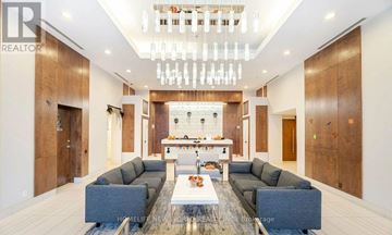 Toronto (Mimico) condo for rent - A modern living room with a large grey sofa set and a chandelier.