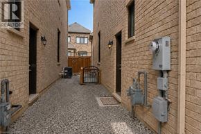 Milton apartment for rent - A narrow alley with gravel on the ground and brick walls on either side.