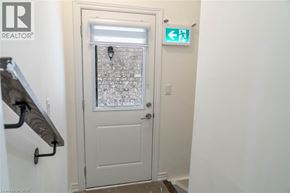 Milton apartment for rent - A white door with a glass window and a green exit sign above it.
