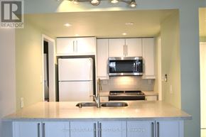 Toronto (Bay Street Corridor) condo for rent - A kitchen with a refrigerator, microwave, and stove top oven.
