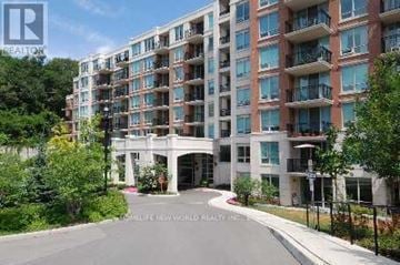 Toronto (St. Andrew-Windfields) condo for rent - A large apartment complex with a driveway in front.
