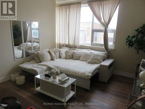 Fort Erie (Central) multi-family for rent - A bedroom with a large bed and a coffee table.