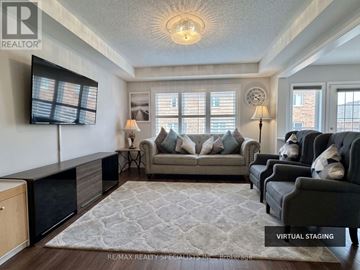 Milton (Fo Ford) townhouse for rent - A living room with a grey couch and a patterned rug.