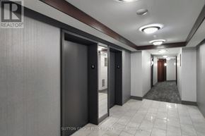 Mississauga (City Centre) condo for rent - A hallway with a brokerage sign on the wall.