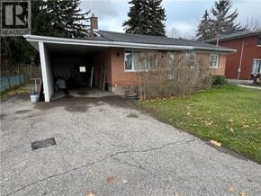 Cambridge apartment for rent - A house with a garage and a tree in front of it.