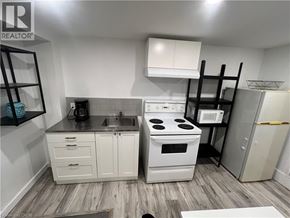 Cambridge apartment for rent - A small kitchen with white cabinets and a black stove top.
