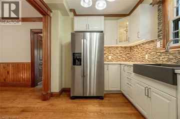 Milton apartment for rent - A kitchen with a stainless steel refrigerator and wooden floors.