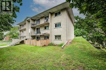 Waterloo apartment for rent - A building with a balcony and a green lawn in front.