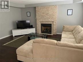 Milton (Be Beaty) apartment for rent - A living room with a beige couch, a fireplace, and a flat screen TV.