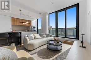Toronto (Mount Pleasant East) condo for rent - A modern living room with a large window and a view of the city.