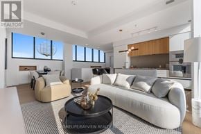 Toronto (Mount Pleasant East) condo for rent - A modern living room with a large sofa, a coffee table, and a dining area.