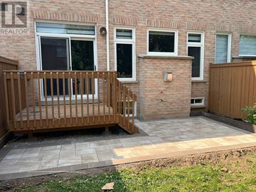 Oakville (Bc Bronte Creek) townhouse for rent - A small balcony with a wooden railing is in front of a brick building.