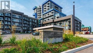 Hamilton (Waterdown) condo for rent - A building with the number 450 on it is surrounded by greenery.