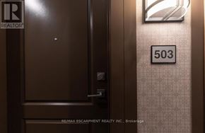 Hamilton (Waterdown) condo for rent - A brown door with a REALTOR sign on it.