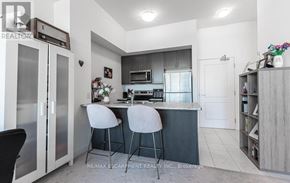 Hamilton (Waterdown) condo for rent - A modern kitchen with a bar area and two stools.