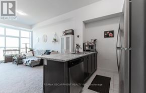 Hamilton (Waterdown) condo for rent - A kitchen area with a refrigerator, sink, and a countertop.