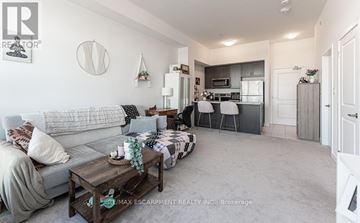 Hamilton (Waterdown) condo for rent - A living room with a grey couch and a coffee table.