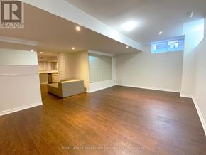 Oakville (Bc Bronte Creek) apartment for rent - A spacious room with wooden flooring and white walls, featuring a built-in bench and a window.