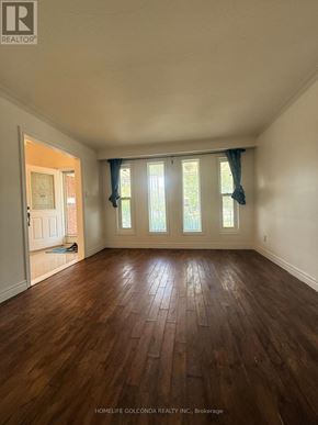 Toronto (Tam O'shanter-Sullivan) apartment for rent - A room with wooden floors and a window with curtains.