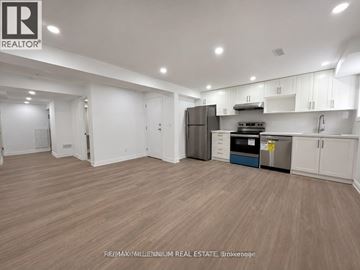 Vaughan (Kleinburg) apartment for rent - A spacious kitchen with white cabinets and a wooden floor.