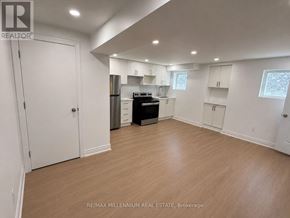 Vaughan (Kleinburg) apartment for rent - A spacious kitchen with white cabinets and a black stove top oven.