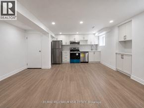 Vaughan (Kleinburg) apartment for rent - A spacious kitchen with white cabinets and a wooden floor.