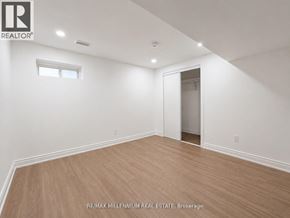 Vaughan (Kleinburg) apartment for rent - A room with a wooden floor and white walls, with a window and a door leading to another room.