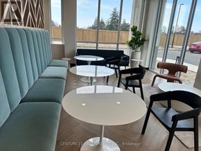 Kitchener condo for rent - A modern waiting room with a green sofa and a round table.