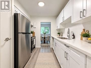 London South (South G) condo for rent - A modern kitchen with white cabinets and a stainless steel refrigerator.