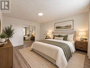 London South (South G) condo for rent - A bedroom with a large bed, a nightstand with a lamp, and a framed picture on the wall.