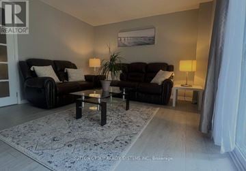 Kitchener townhouse for rent - A living room with two black couches and a coffee table.