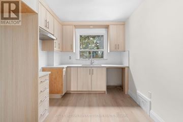 Toronto (Brookhaven-Amesbury) apartment for rent - A kitchen with wooden cabinets and a window.