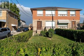 Toronto (Brookhaven-Amesbury) apartment for rent - A house with a brown door and windows is surrounded by green bushes.