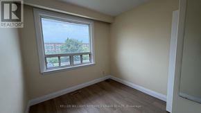 Toronto (Brookhaven-Amesbury) apartment for rent - A room with a window showing a view of a building and trees outside.