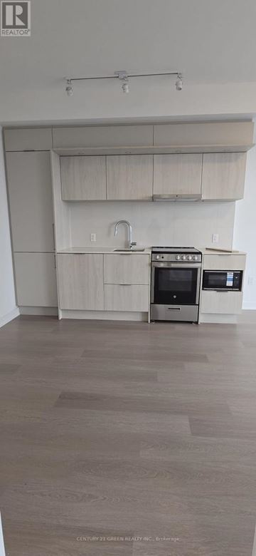 Mississauga (City Centre) condo for rent - A kitchen with a stove top oven and a microwave.