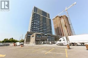 Milton (Co Coates) condo for rent - A white truck is parked in a lot with a building under construction in the background.