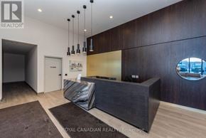 Milton (Co Coates) condo for rent - A modern office lobby with a dark wood wall and a circular window.