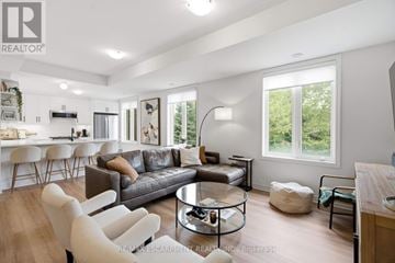 Hamilton (Waterdown) townhouse for rent - A modern living room with a grey sofa and a glass coffee table.