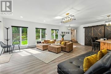 Gravenhurst (Muskoka (S)) apartment for rent - A modern living room with a black leather couch and a wooden cabinet.