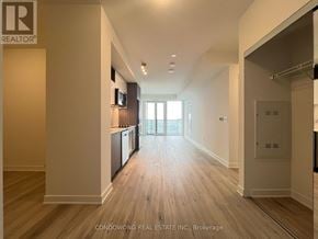 Toronto (Waterfront Communities) condo for rent - A spacious hallway with wooden floors and a large window.