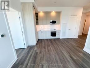 Vaughan (Vaughan Corporate Centre) condo for rent - A modern kitchen with white cabinets and a wooden floor.