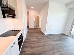 Vaughan (Vaughan Corporate Centre) condo for rent - A kitchen with white cabinets and a wooden floor.