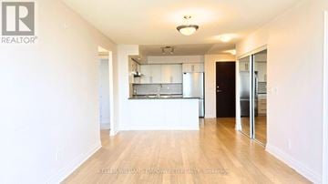Markham (Unionville) condo for rent - A spacious kitchen with white cabinets and a wooden floor.