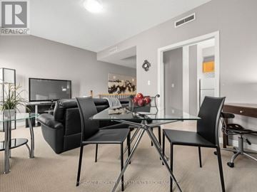 Vaughan (Kleinburg) apartment for rent - A modern living room with a glass table and black chairs.