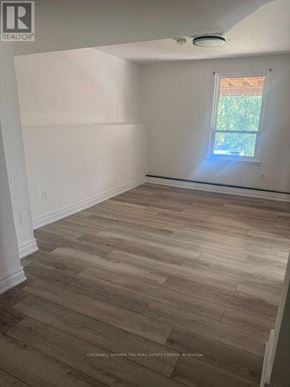 Barrie (Letitia Heights) apartment for rent - A room with wooden flooring and a window letting in sunlight.