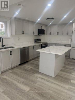 Barrie (Letitia Heights) apartment for rent - A kitchen with white cabinets and a white island.