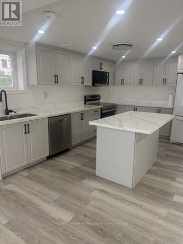 Barrie (Letitia Heights) apartment for rent - A kitchen with white cabinets and a white island.