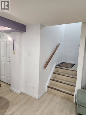 Kitchener apartment for rent - A staircase with a wooden handrail and a rug on the steps.